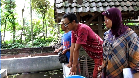  Farmer with Disabilities Feeding Catfish