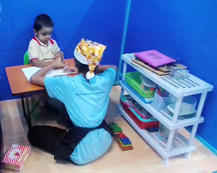 A young boy with autism being mentored by a special education teacher at the MAA Daycare