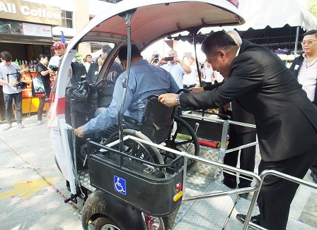 A wheelchair user trying out the accessible motorized tricycle