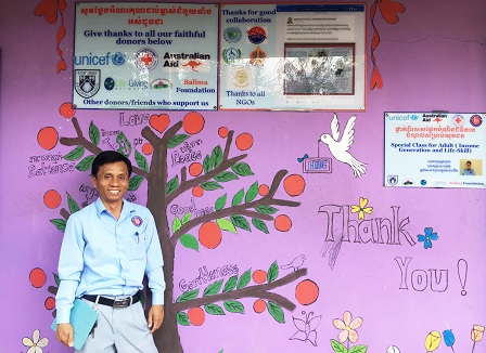 HHC Founder and Executive Director Mr. Chan Sarin posing at the school's gratitude wall
