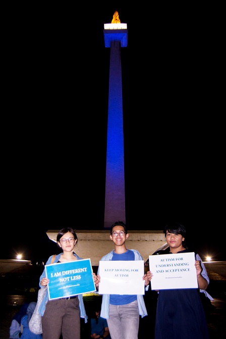 YAI supporters and members in front of the blue-lighted National Monument