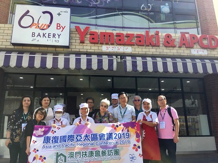 Group photo with 60+ Plus Bakery & Cafe staff with disabilities