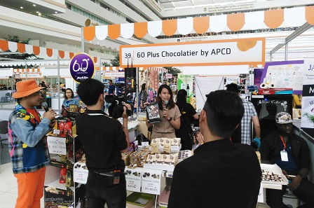 APCD Senior Graphic Designer Ms. Nongnart Sutheerawatthananont explaining the chocolate products to the host of the event
