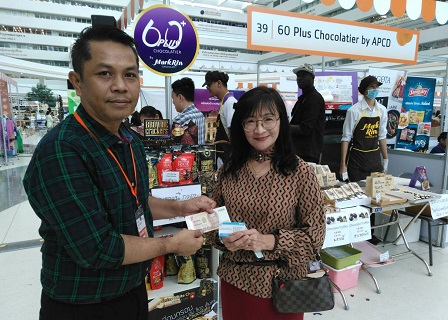 60+ Plus Bakery and Cafe Project Manager Mr. Sunthorn Nowarat accepts donation from a customer