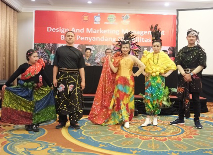 Fashion show with persons with disabilities wearing various batik-designed attire