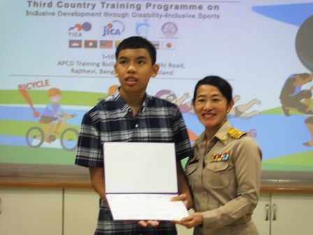 Ms. Vijita Rachatanantikul (Expert on Empowerment of Persons with Disabilities, Department of Empowerment of Persons with Disabilities) presents certificate to Thai delegate with autism