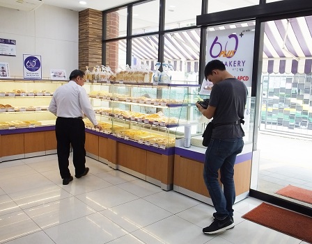 Camera crew taking photos of Mr. Piroon at the bakery showroom