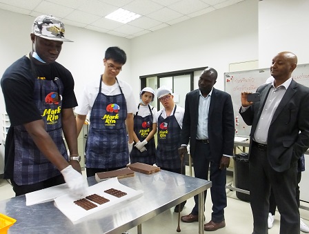 Delegates observing the on-the-job training on chocolate making by trainees with diverse disabilities